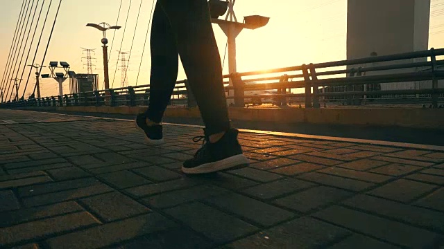 在阳光下的桥上行走的人的腿视频下载