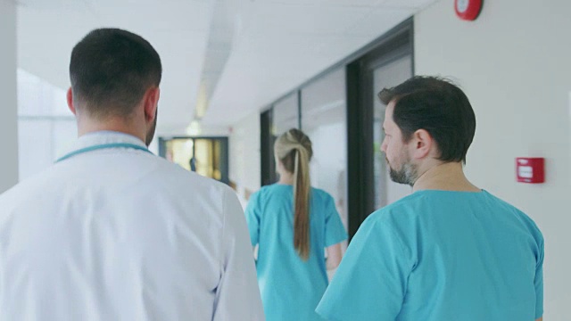 一个医生和外科医生匆忙穿过医院走廊的背影拍摄。医护人员拯救生命。视频素材