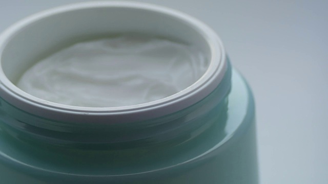 绿色的罐子里装着温和的护肤霜。化妆品霜宏观近距离观察视频素材