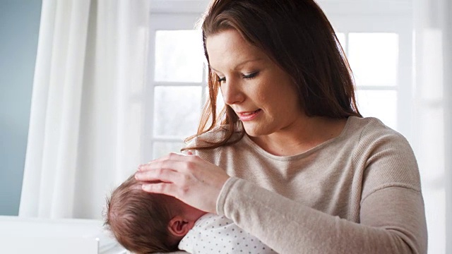 慈母在家里抱着熟睡的新生男婴视频素材