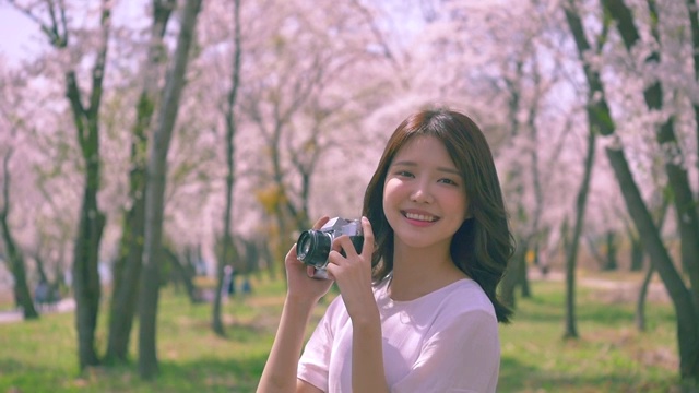 一个韩国女人拍樱花树的照片视频下载