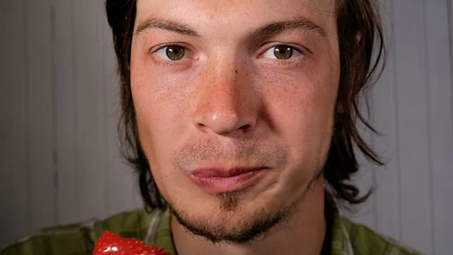 一个年轻的欧洲人正在狼吞虎咽地吃着一个草莓视频下载