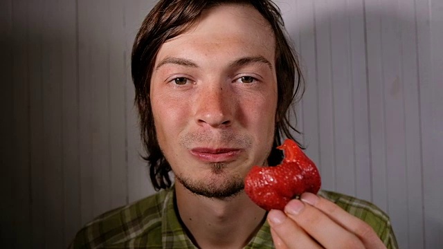 欧洲男子正在狼吞虎咽地吃草莓的特写，慢动作视频下载
