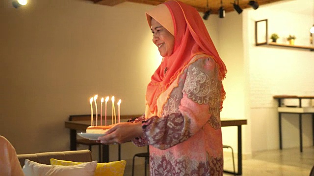 一位亚洲妇女正在给她的丈夫送生日蛋糕视频素材