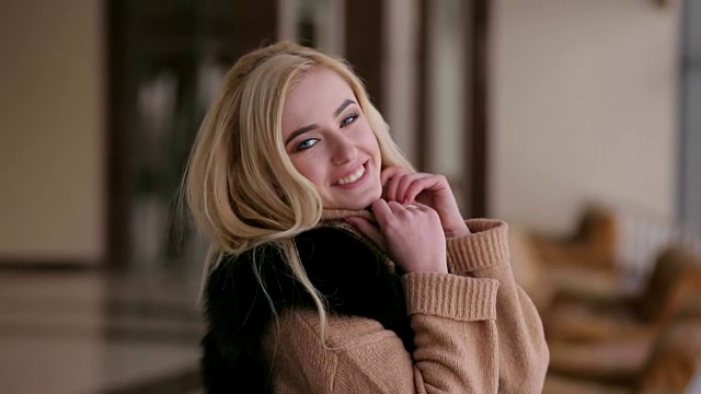 酒店里一个穿着棕色毛衣的女孩的肖像视频素材