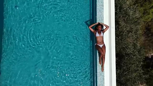 鸟瞰图的一个女人日光浴的无限池视频素材
