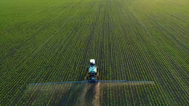 4K无人机拍摄的画面。在大豆田上跟着拖拉机喷雾器视频素材