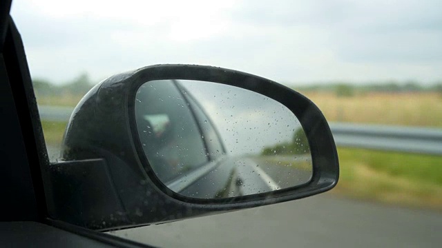 在雨天从后视镜看到的道路视频素材