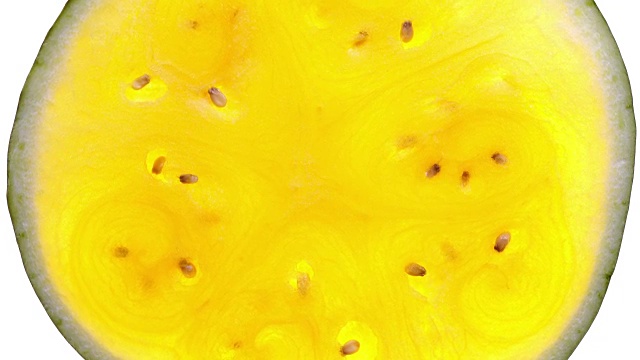 令人惊叹的俯视图，整个一片黄色的西瓜，旋转的白色背景与背光顺时针靠近。视频下载