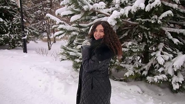 一个怀孕女孩在一个公园里的肖像在一个降雪。视频素材