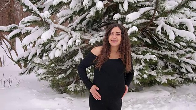 美丽的怀孕女孩在冬季公园散步视频素材