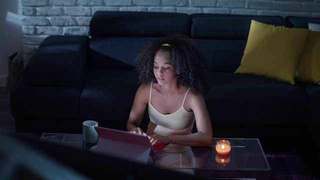 年轻的拉丁女子在晚上用笔记本电脑打字视频素材
