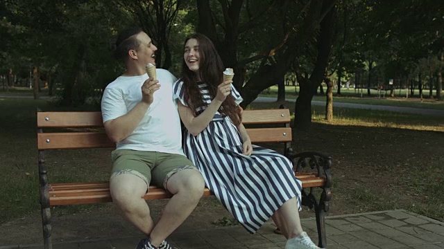 一对兴高采烈的孕妇夫妇在公园里吃冰淇淋视频素材