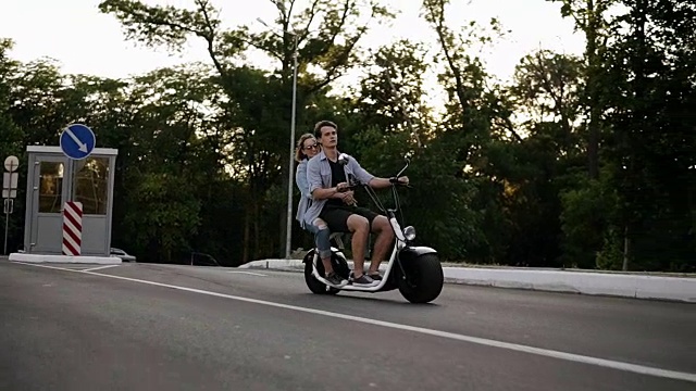 一对夫妇骑自行车和有乐趣的侧视图。年轻漂亮的女人和男人在城里兜风。自由,快乐的生活方式视频下载