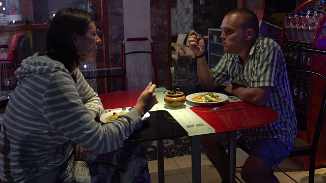 一男一女坐在餐馆里吃着炖菜视频素材