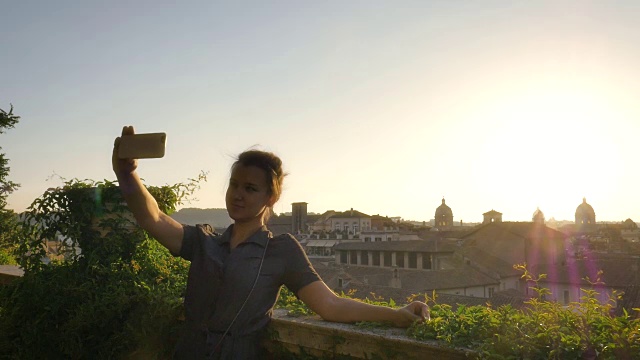 一名年轻女子在阳台上自拍罗马市景视频下载