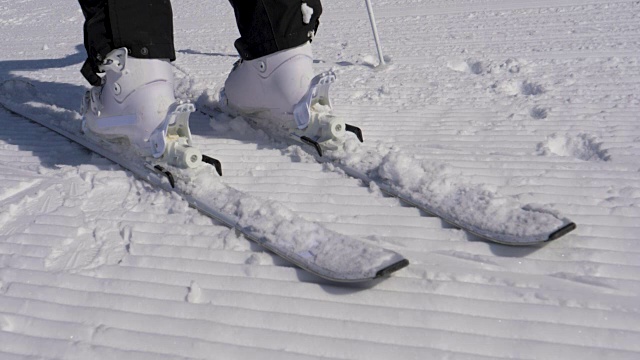 在一个阳光明媚的日子里，滑雪者踩进滑雪绑定与他的滑雪靴视频下载