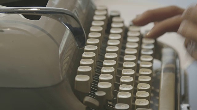 一个女人在一台老式打字机上打字的手的特写镜头视频素材