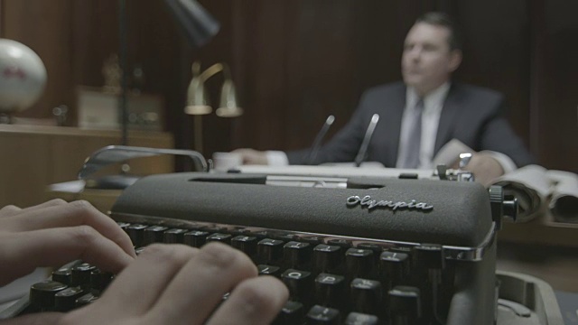 一个女人在办公室打字的手的特写镜头，背景是经理视频素材