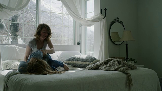 慢动作的母亲胳肢女儿和枕头大战在床上/ Pleasant Grove，犹他州，美国视频下载