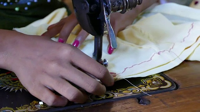 缅甸，东南亚蒲甘，妇女在市场上使用缝纫机视频下载