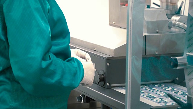 穿着防护服的工人控制把药片分装的过程视频素材