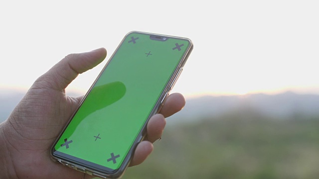 在大自然中使用和清扫绿色屏幕智能手机，色度键视频下载