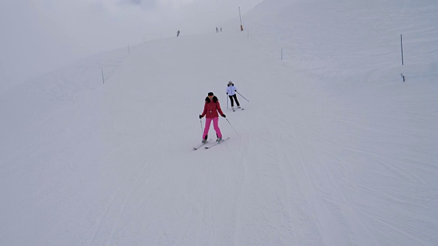 冬天浓雾中，滑雪者在山坡上滑雪视频下载