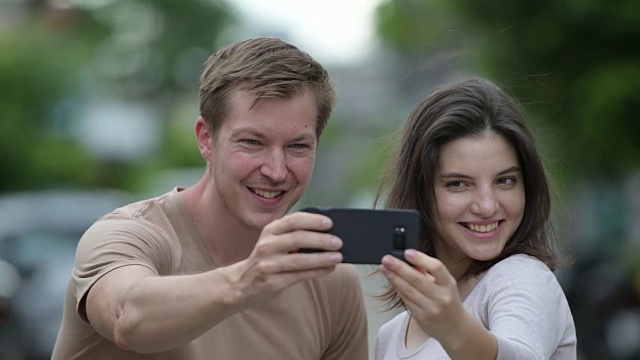 一对年轻幸福的情侣在户外的街道上自拍视频下载