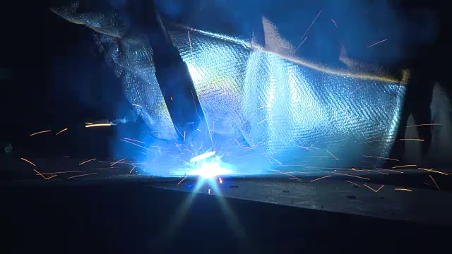 一个工具发出强烈的蓝色光被用于焊接在格拉斯哥，苏格兰船厂的特写。视频下载