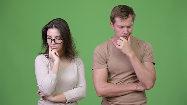 年轻的悲伤的夫妇一起思考在绿色的背景视频下载