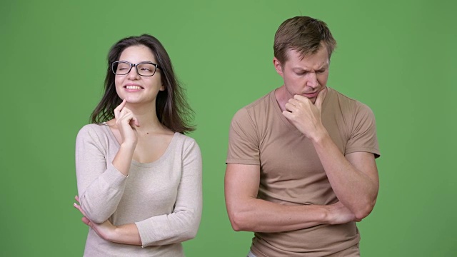 一对年轻夫妇在绿色背景下一起思考视频下载