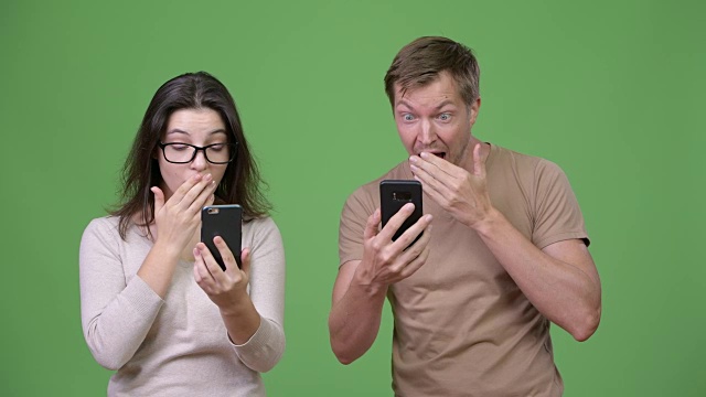 年轻夫妇使用电话和看起来震惊在一起视频下载