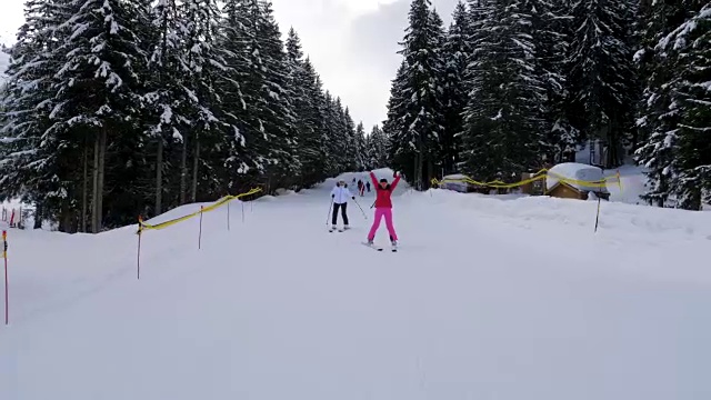 快乐的女人滑雪者在山上的森林斜坡上滑雪并举起手臂视频素材