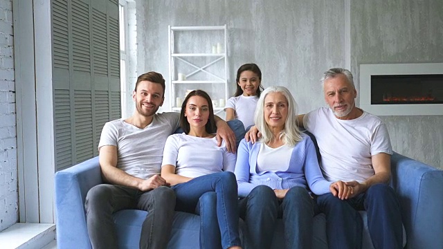 幸福的一家人坐在沙发上。慢动作视频下载