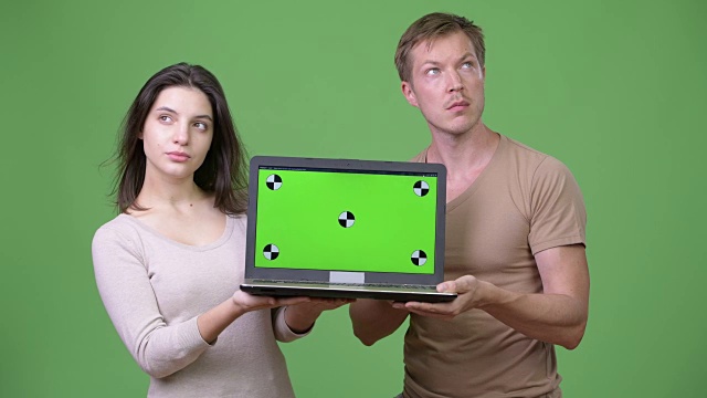 年轻夫妇展示笔记本电脑和一起思考视频下载
