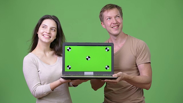 年轻幸福的夫妇展示笔记本电脑和一起思考视频下载