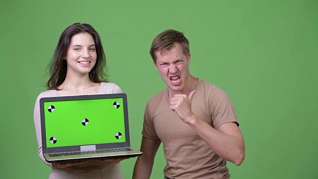年轻的幸福夫妇展示笔记本电脑和得到好消息在一起视频下载