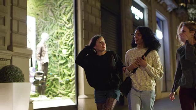 夜晚，快乐的朋友们走在城市的人行道上视频素材