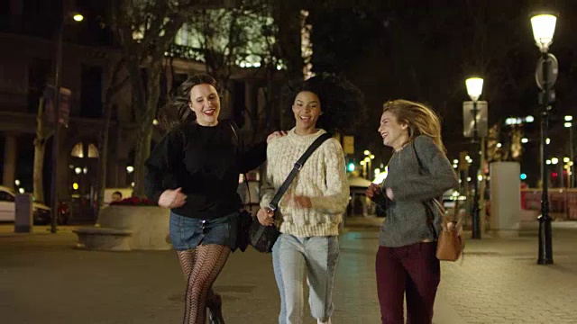 快乐的女人在夜生活的人行道上奔跑视频素材