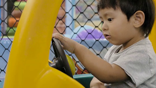 亚洲小男孩骑着一辆玩具车视频素材