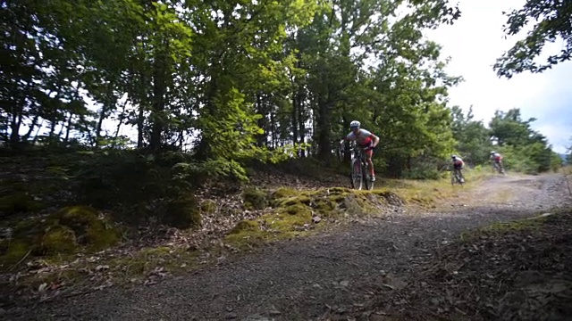 年轻的男运动员在森林里骑自行车视频素材