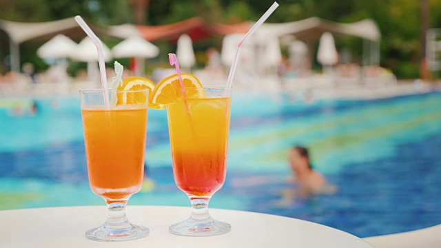 两个异国情调的鸡尾酒在背景的游泳池在旅游胜地视频素材