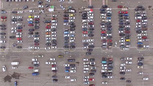 航拍镜头飞过大型超市附近一个又脏又忙的停车场视频下载