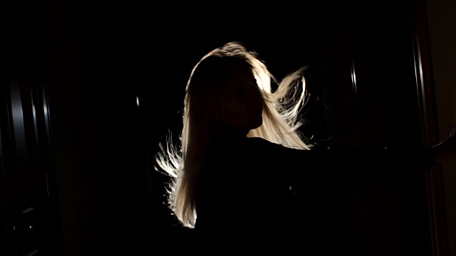一个黑发飘动的女孩的剪影。视频素材