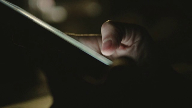 一名亚洲女性在深夜使用智能手机。视频下载