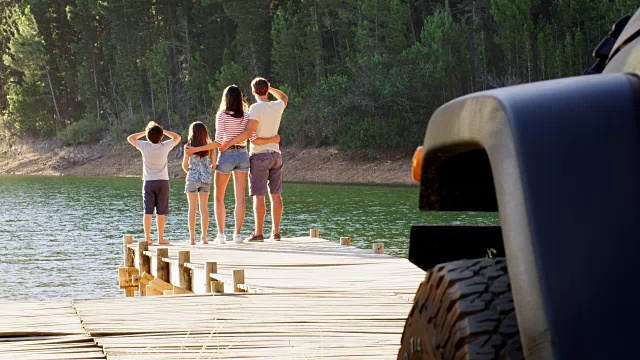 孩子们跑去和父母一起欣赏码头的湖滨景色视频素材