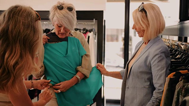 时尚的高级女性在服装店选购服装视频素材