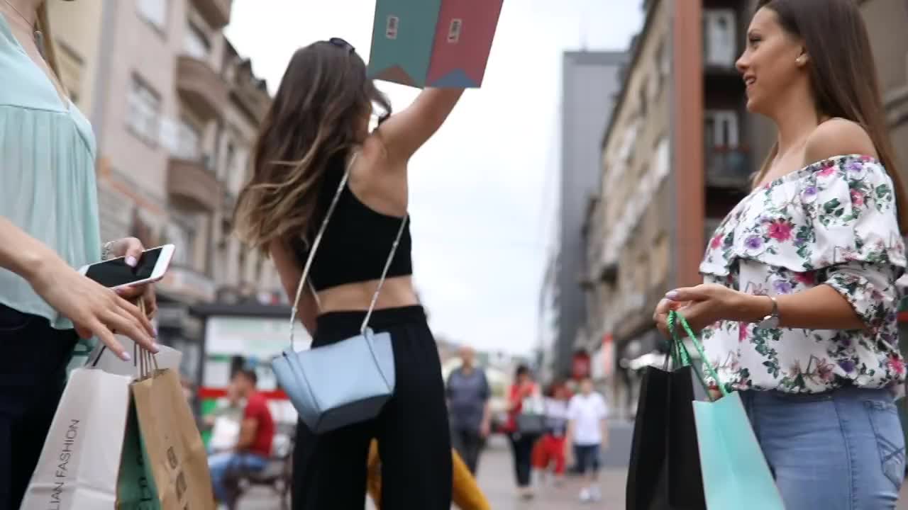 漂亮女人购物后在城市里玩视频素材