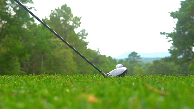 高尔夫球运动的概念。慢动作高尔夫球手打高尔夫球洞赢家在高尔夫球场是美丽的球道日落视频素材